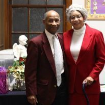 a man and a woman in red suits are posing for a picture .