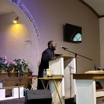 two men are standing at a podium in a church .