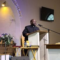 a man is standing at a podium giving a speech in a church .