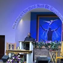 a man is standing at a podium giving a speech in a church .