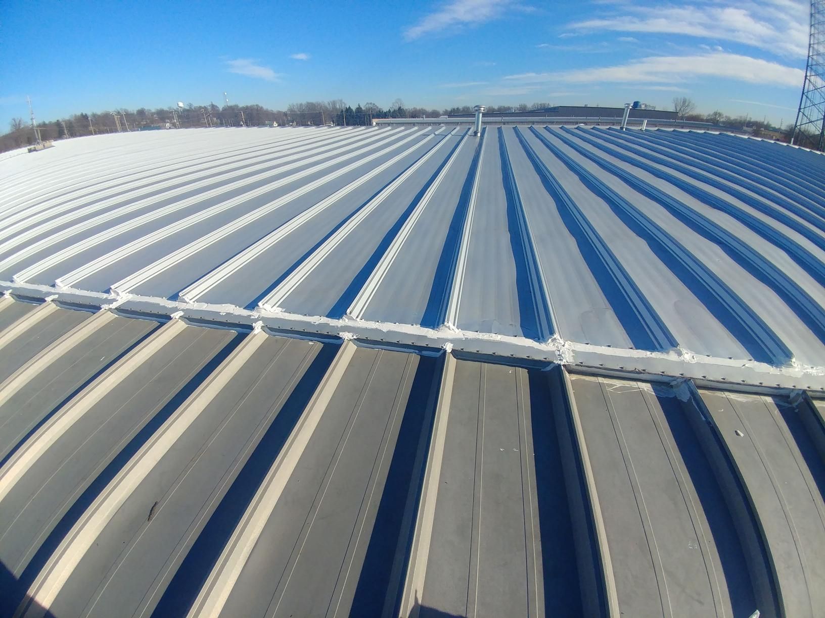A large metal roof with a blue sky in the background