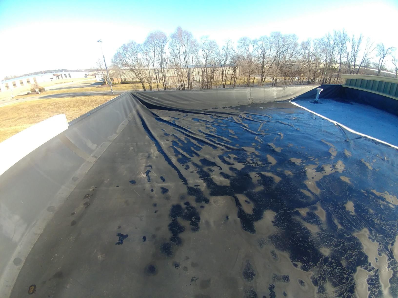 A black tarp is covering the roof of a building.