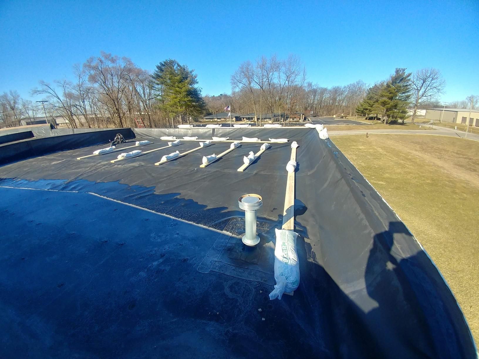 A roof with a lot of pipes on it and trees in the background.