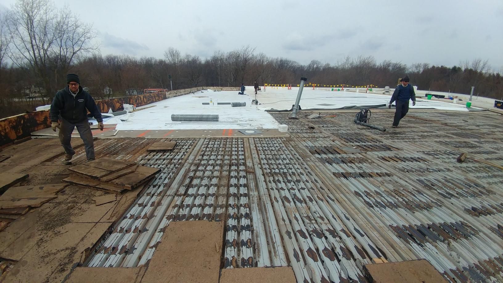 A couple of people are standing on top of a roof.