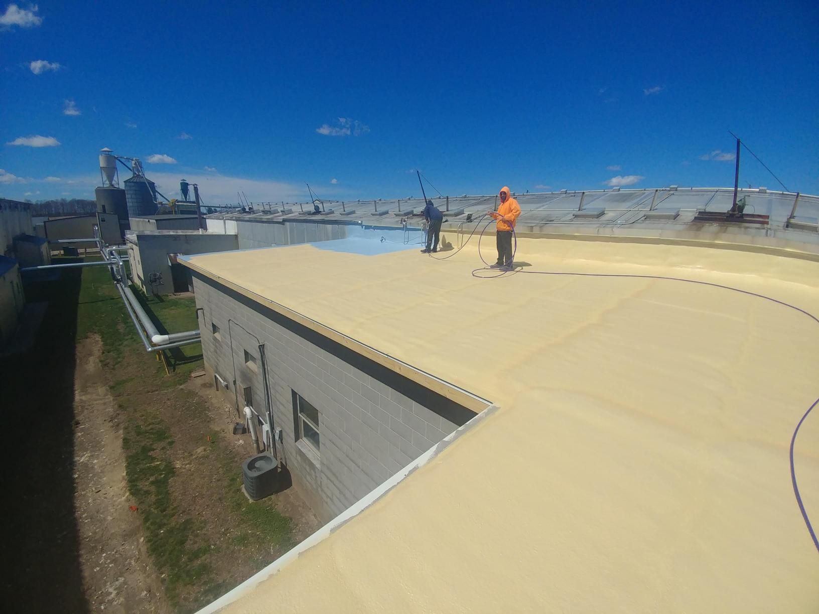 Two men are working on the roof of a building.