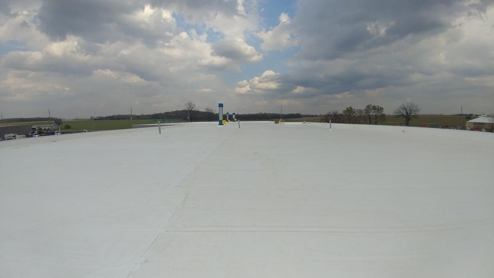 A snowy field with a blue sky and clouds in the background.