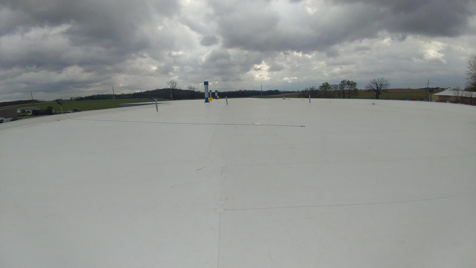 A large white roof with a cloudy sky in the background.