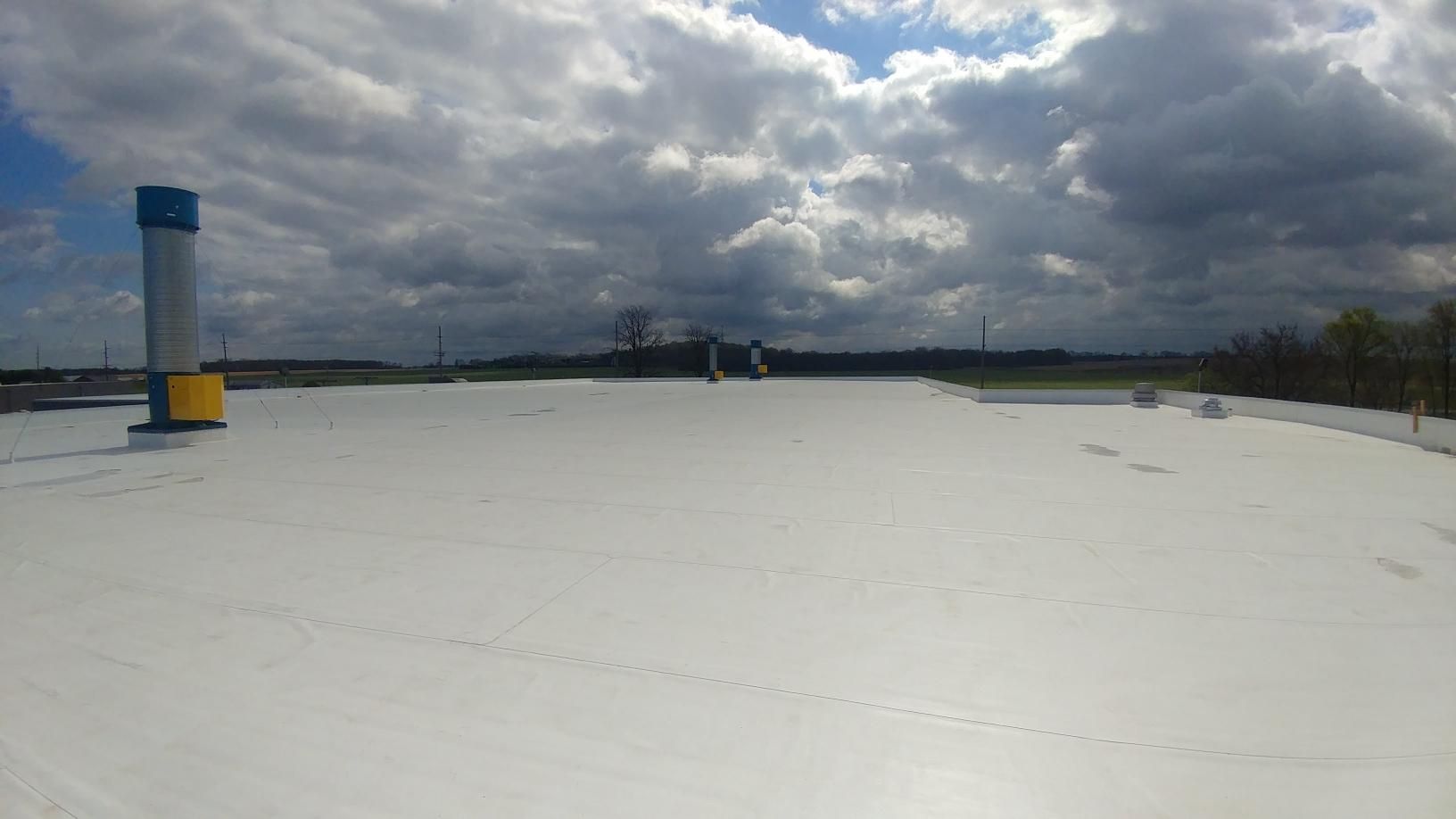 A large white roof with a blue chimney on top of it.