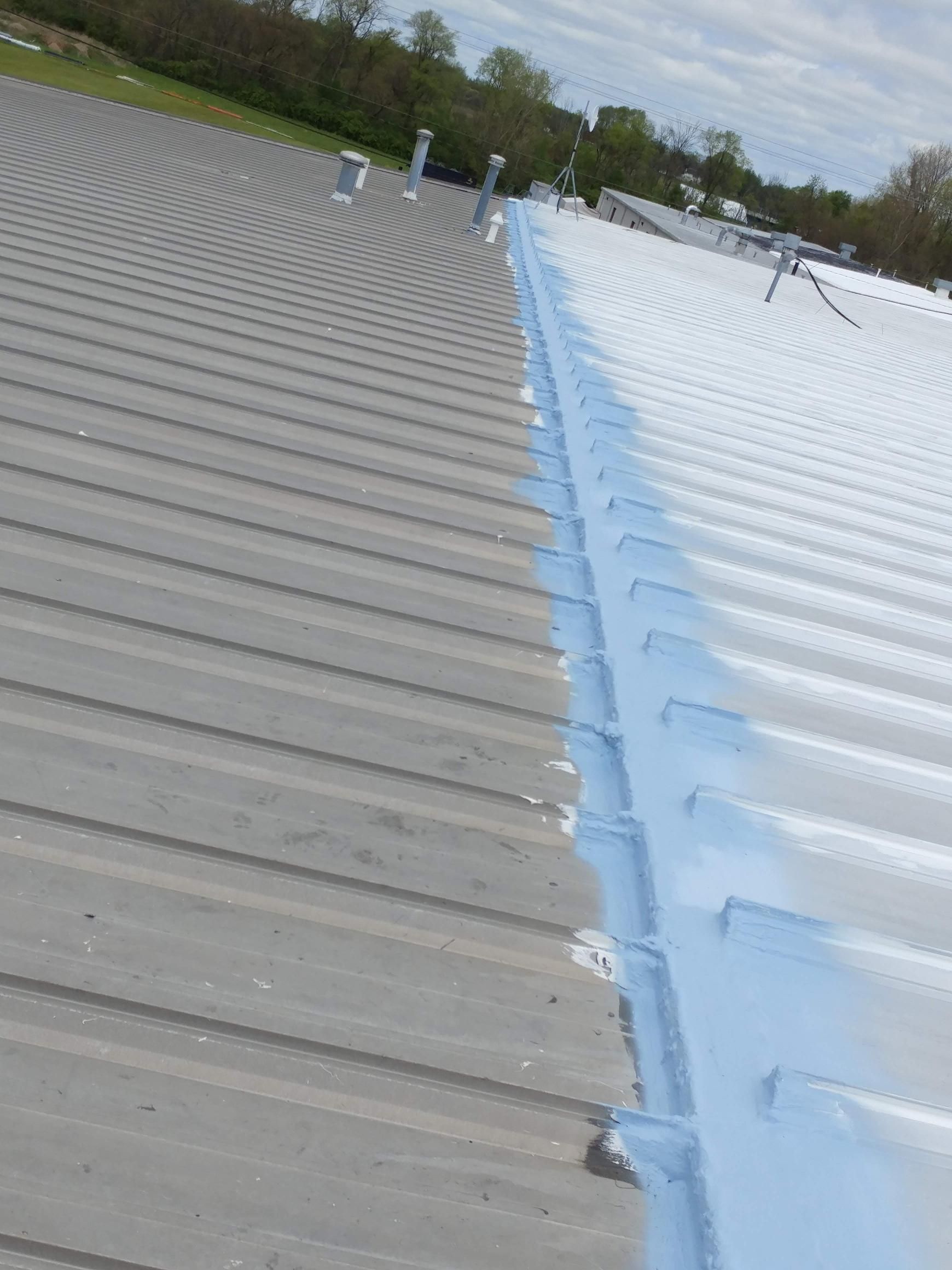 A gray and white roof with a blue gutter.
