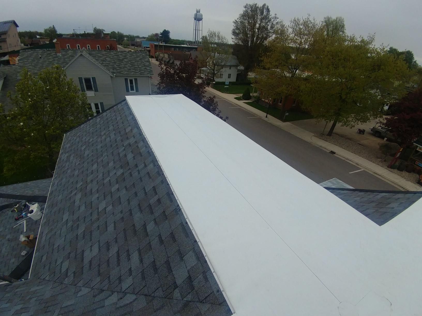 An aerial view of a roof with a water tower in the background