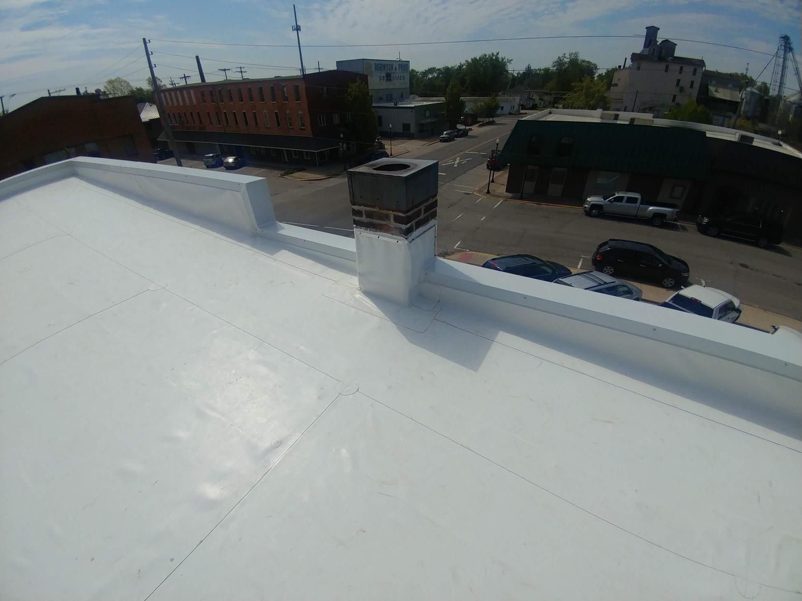 A white roof with a chimney on top of it.