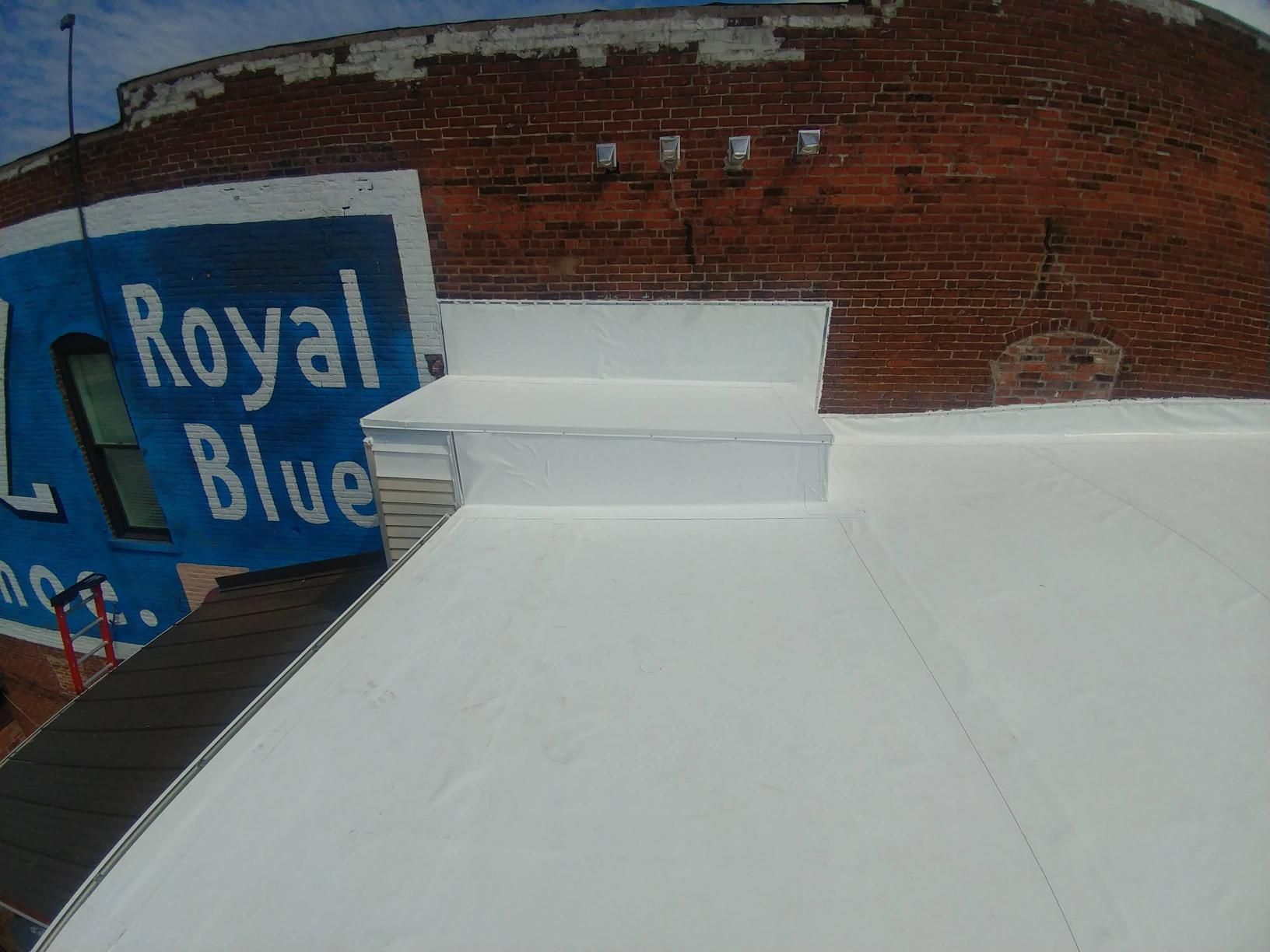A brick building with a white roof and a blue sign that says royal blue