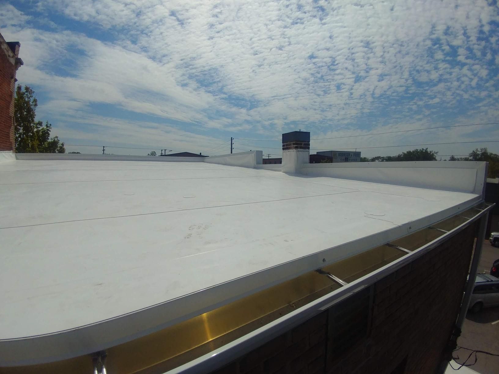 A white roof with a chimney on top of it.