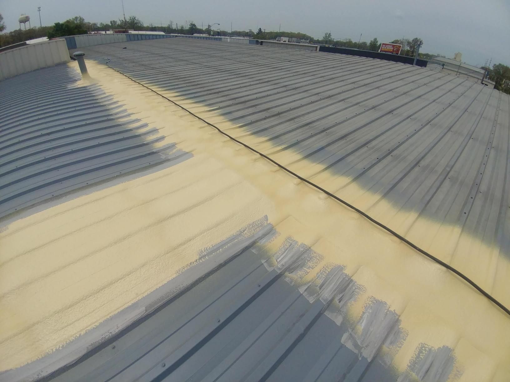 The roof of a building is being sprayed with foam.