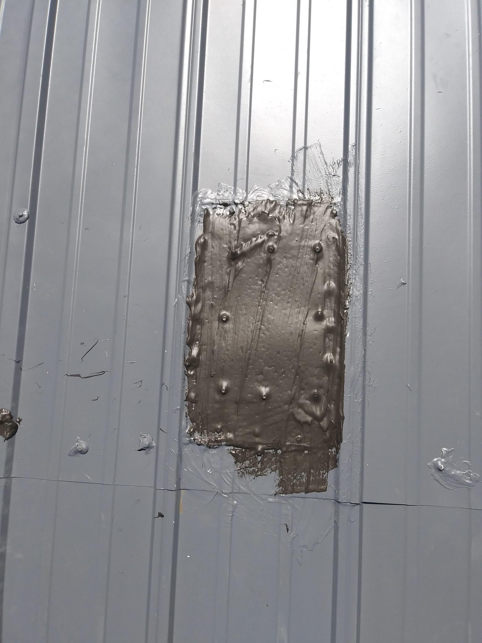 A piece of concrete is sitting on top of a metal wall.