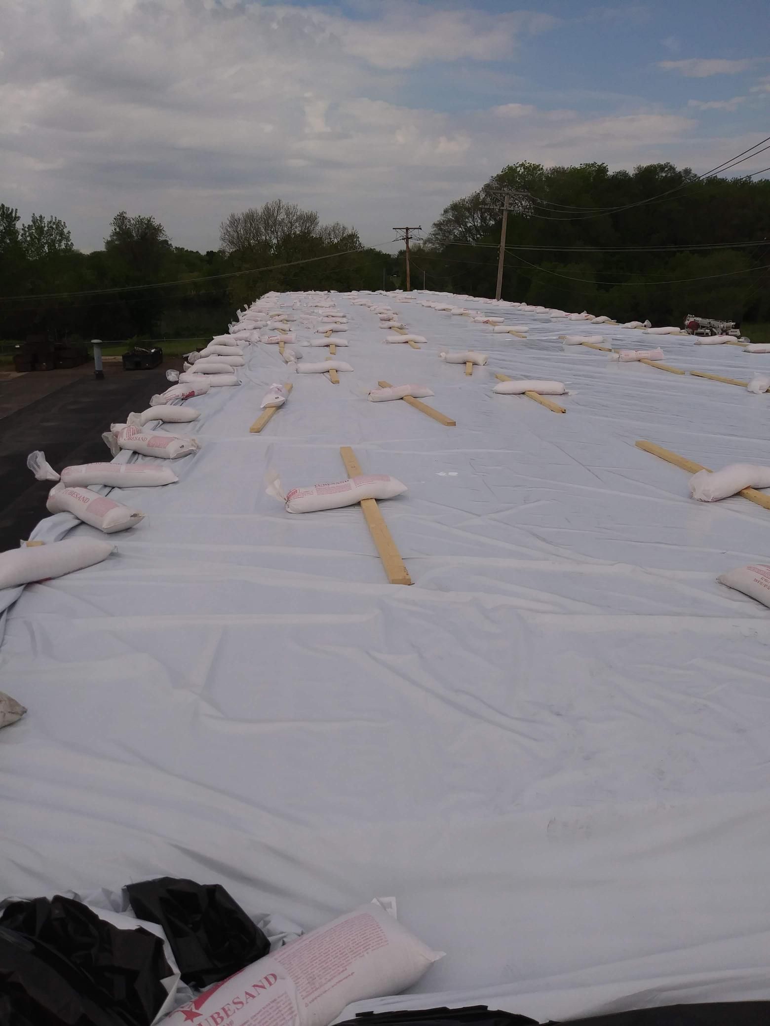 A large white tarp is covering the roof of a building.