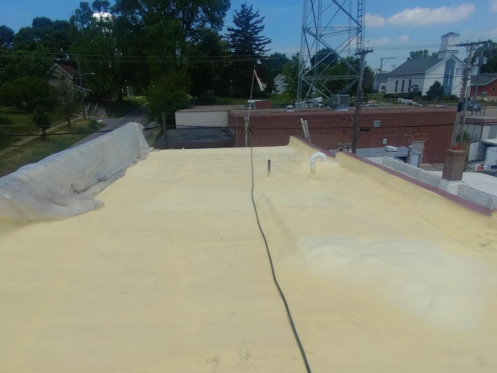 The roof of a building is covered in yellow foam.
