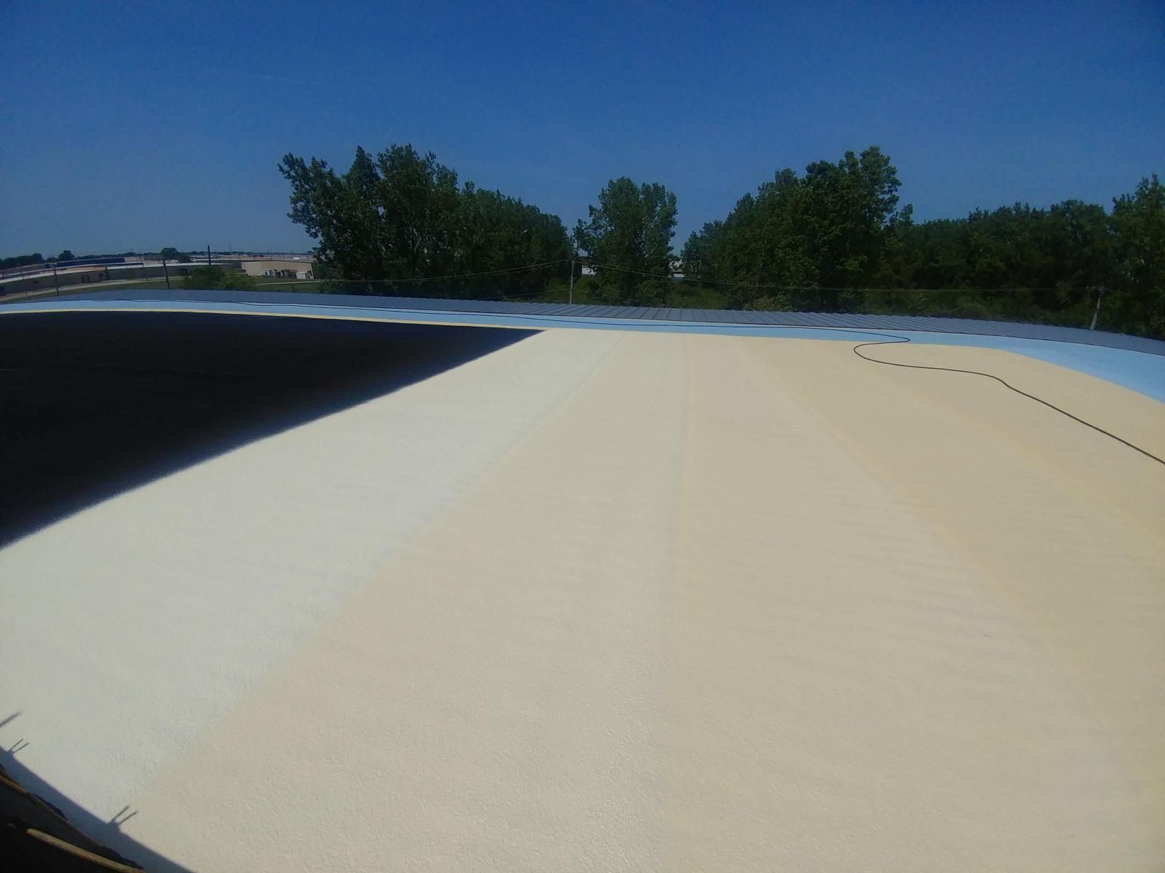 A roof with trees in the background and a blue sky