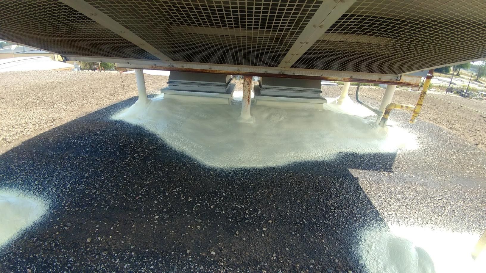A large fan is sitting on top of a pile of gravel.