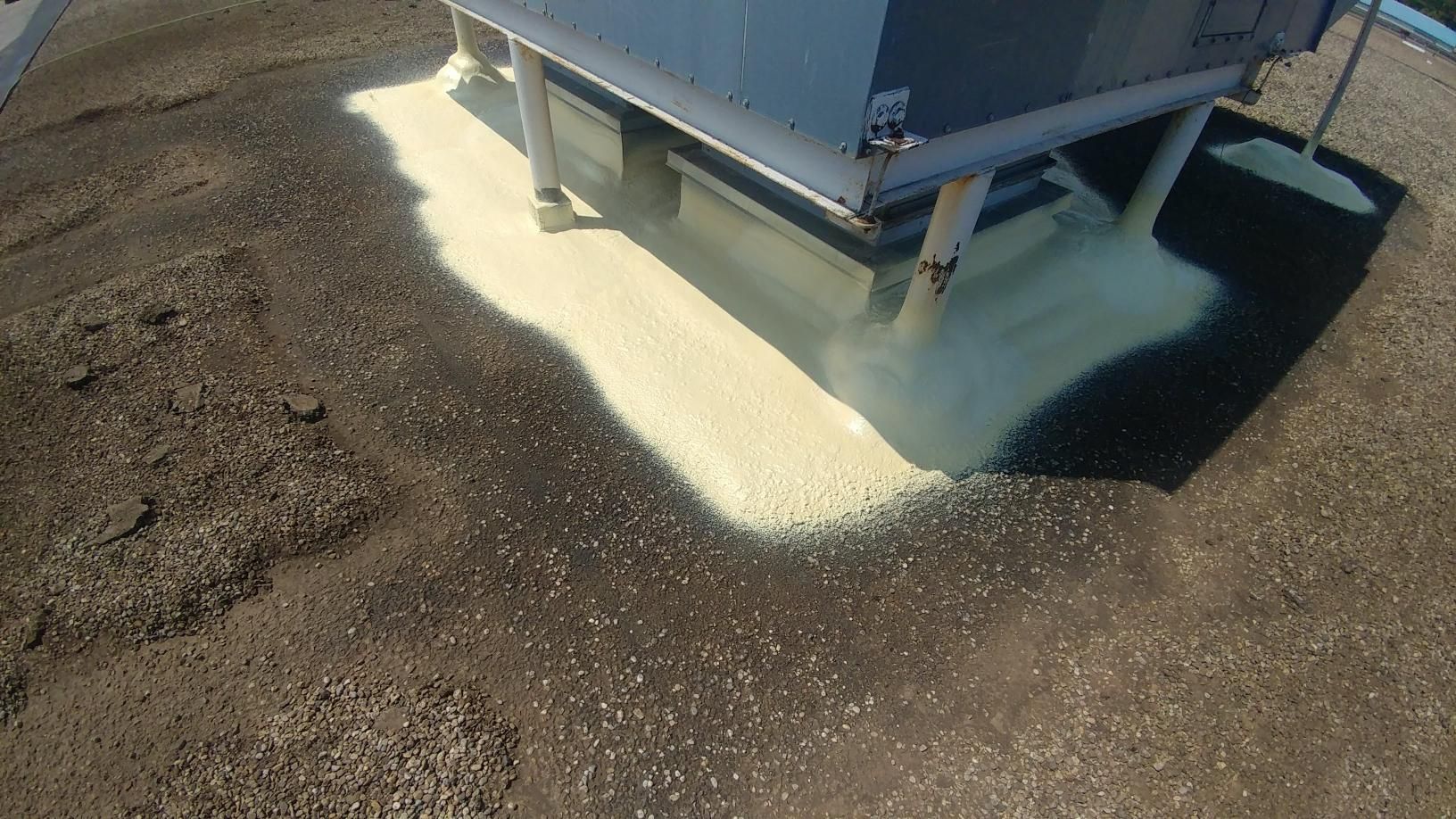 A large container is sitting on top of a dirt field.
