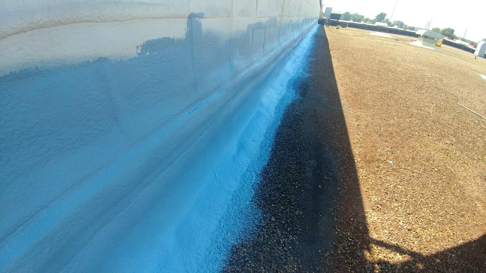 A shadow of a person is cast on a blue wall.
