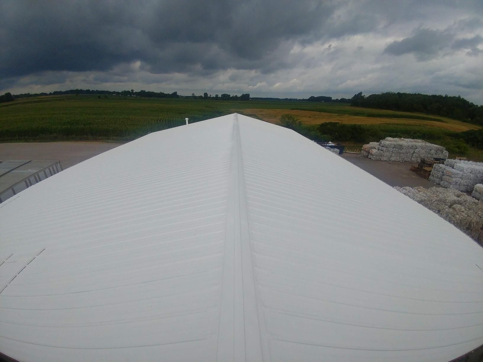A large white roof with a cloudy sky in the background