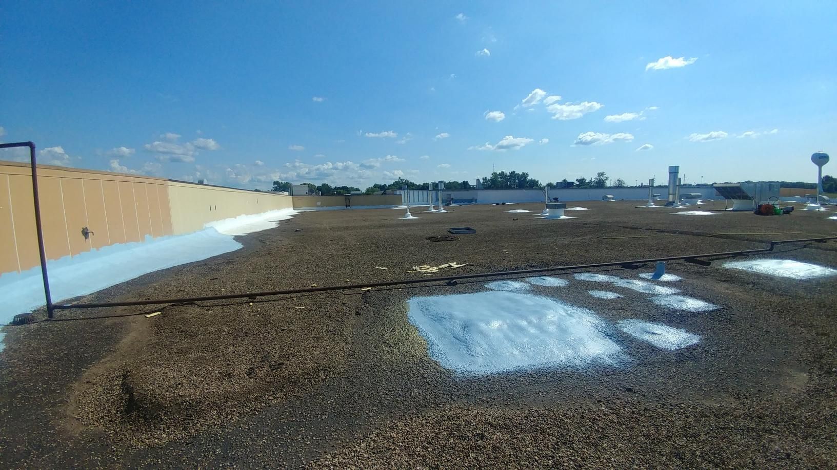 A roof with a lot of water on it and a blue sky in the background.