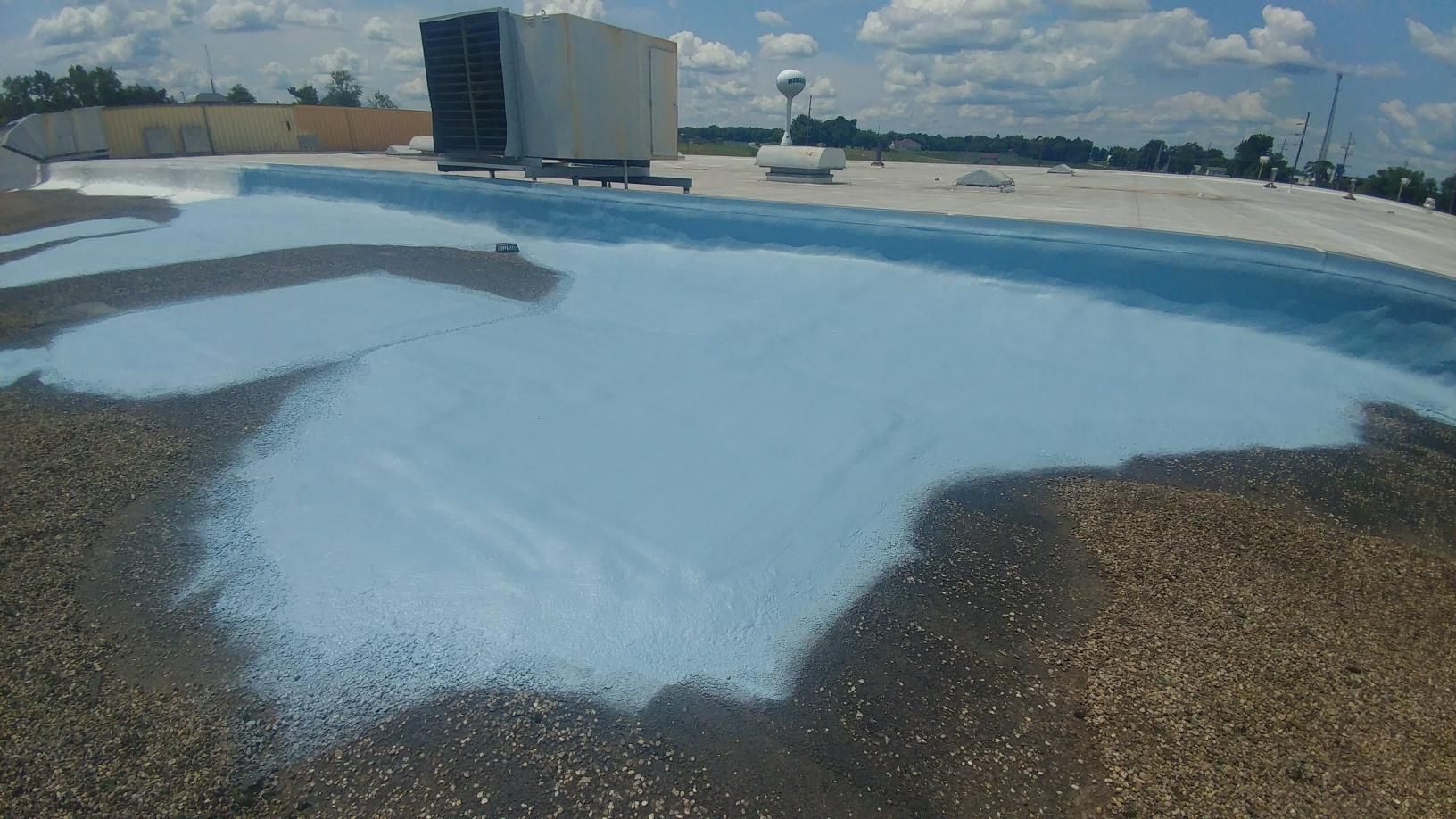 A pool is being painted on the roof of a building.