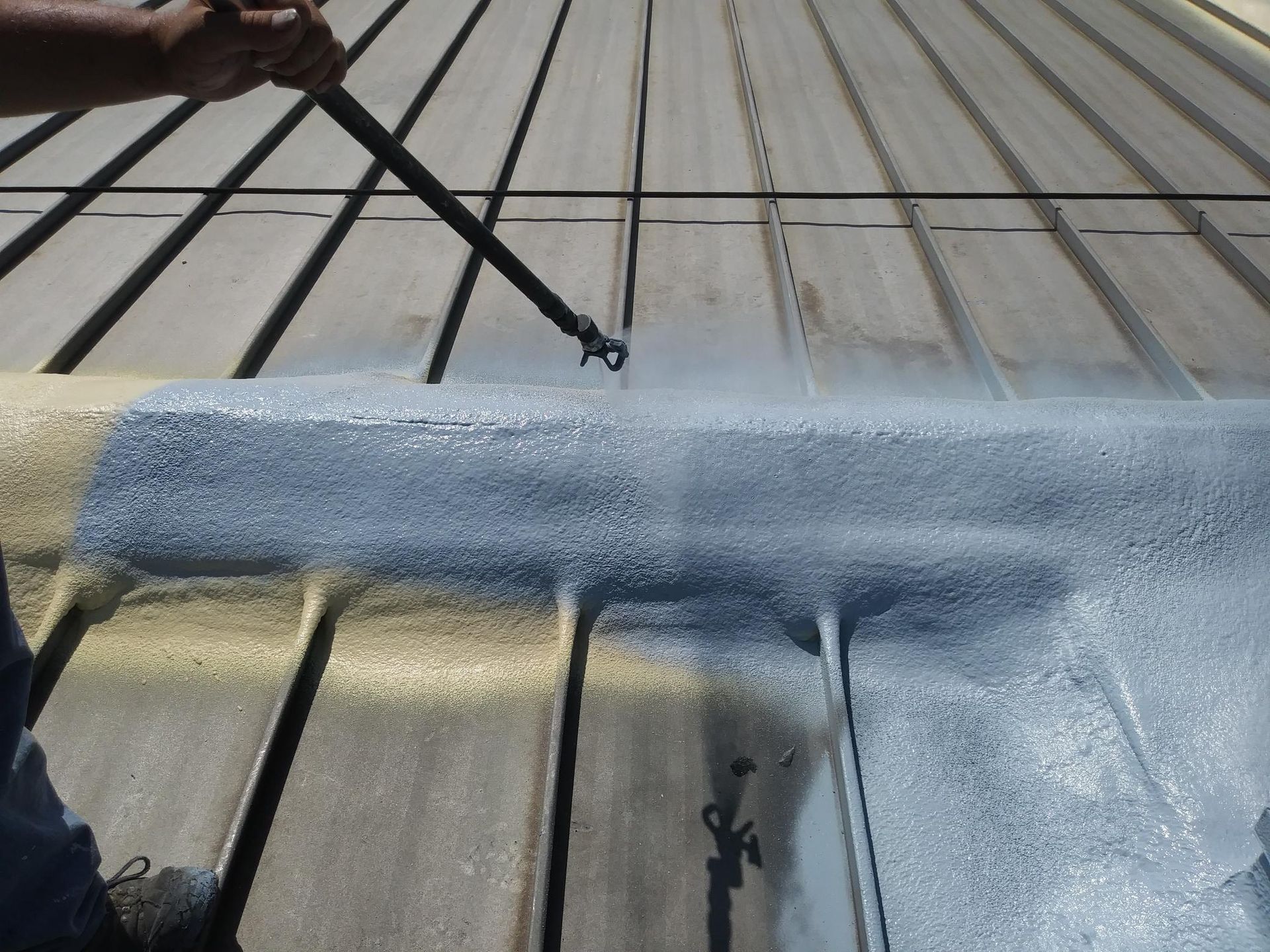 A person is painting a roof with a brush