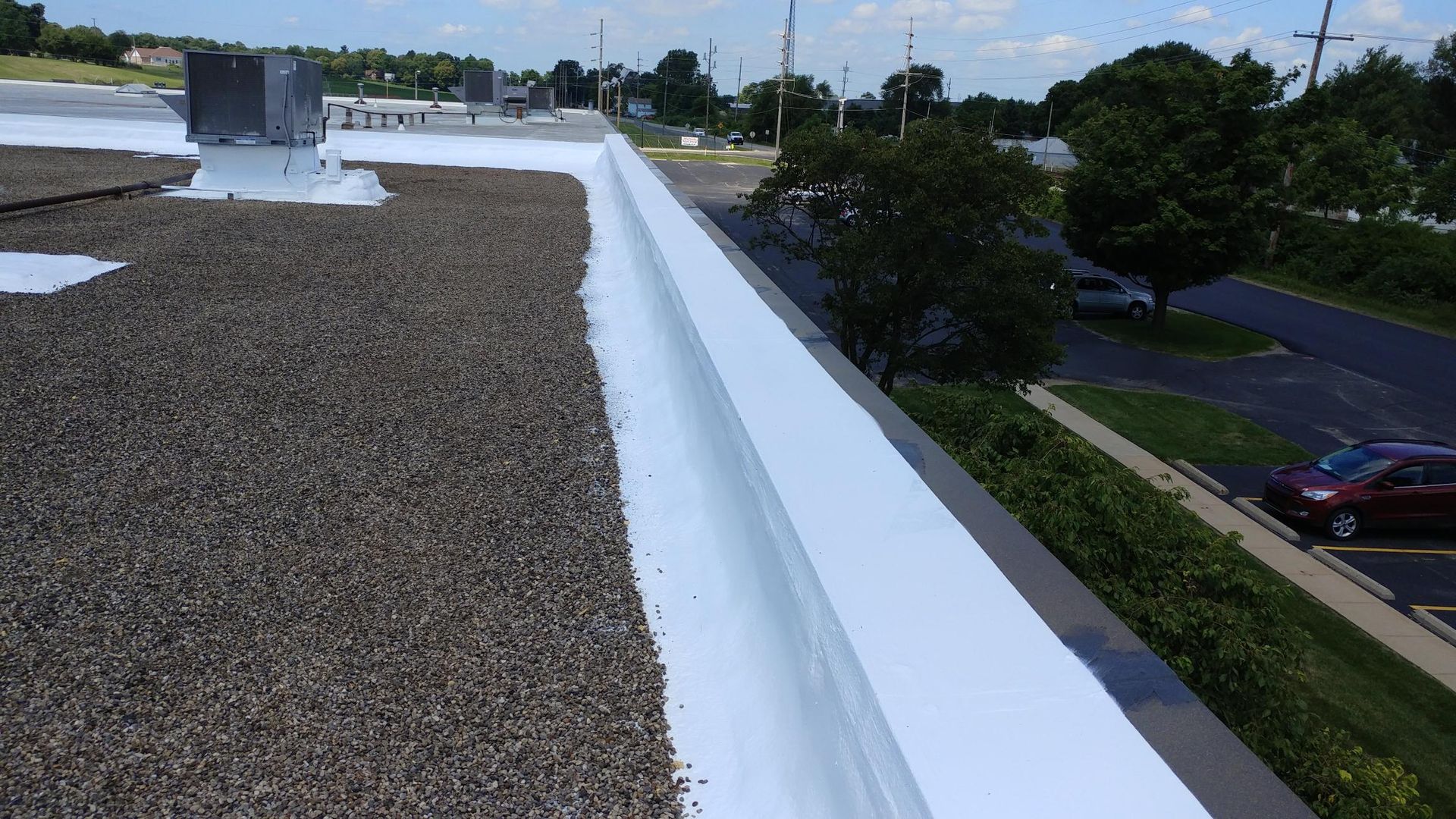 The roof of a building with a white gutter on it