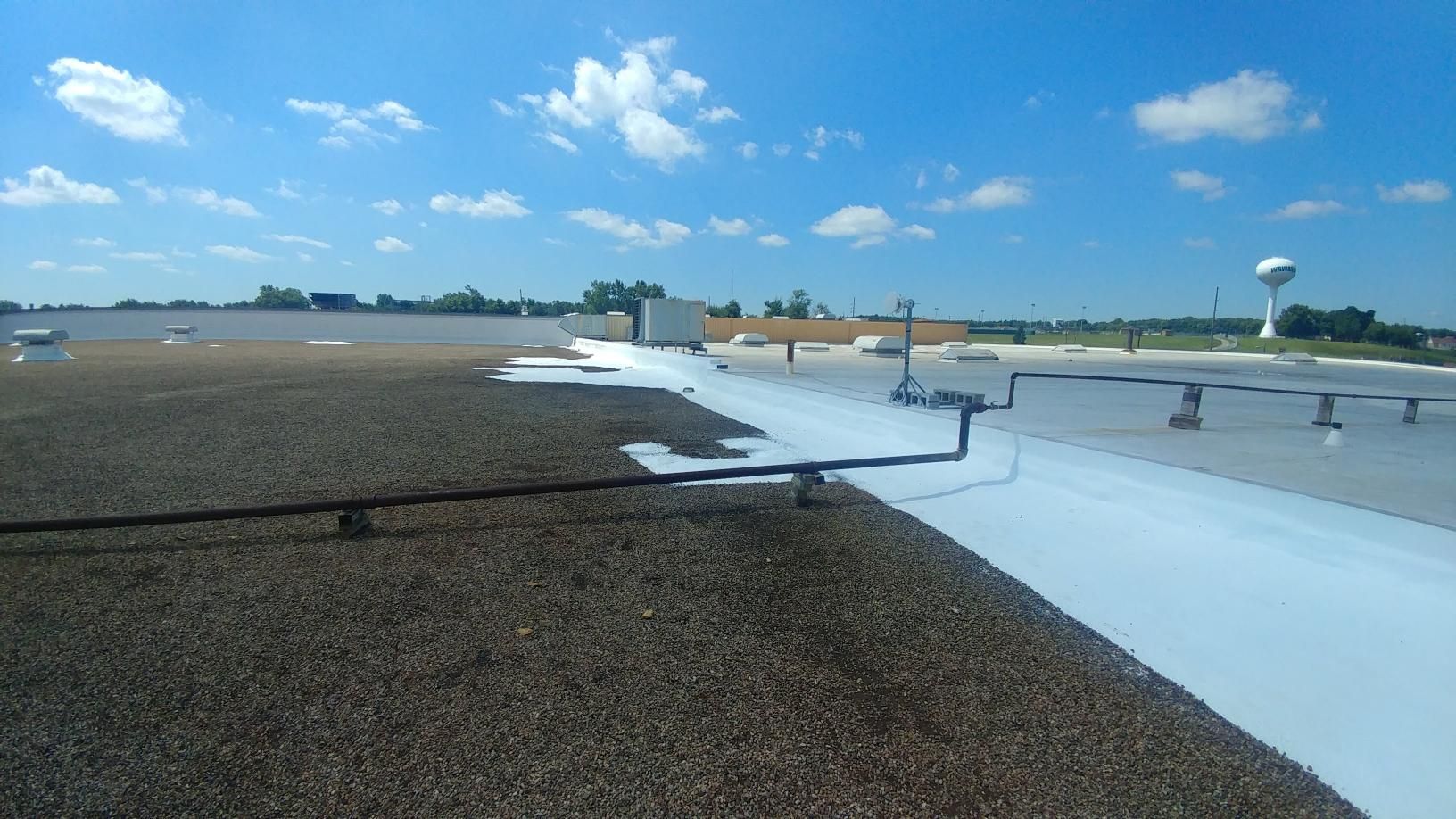 The roof of a building with a water tower in the background.