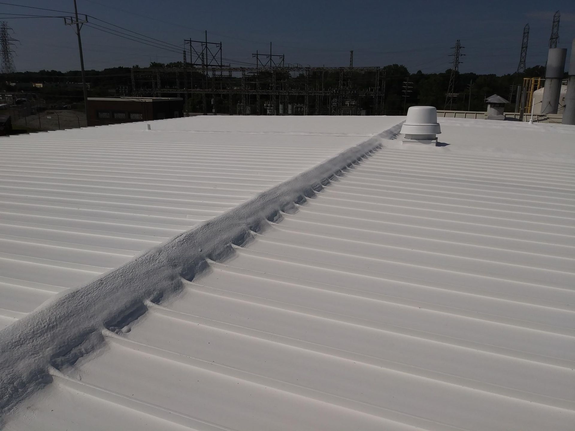 A white roof with a vent on the side of it.