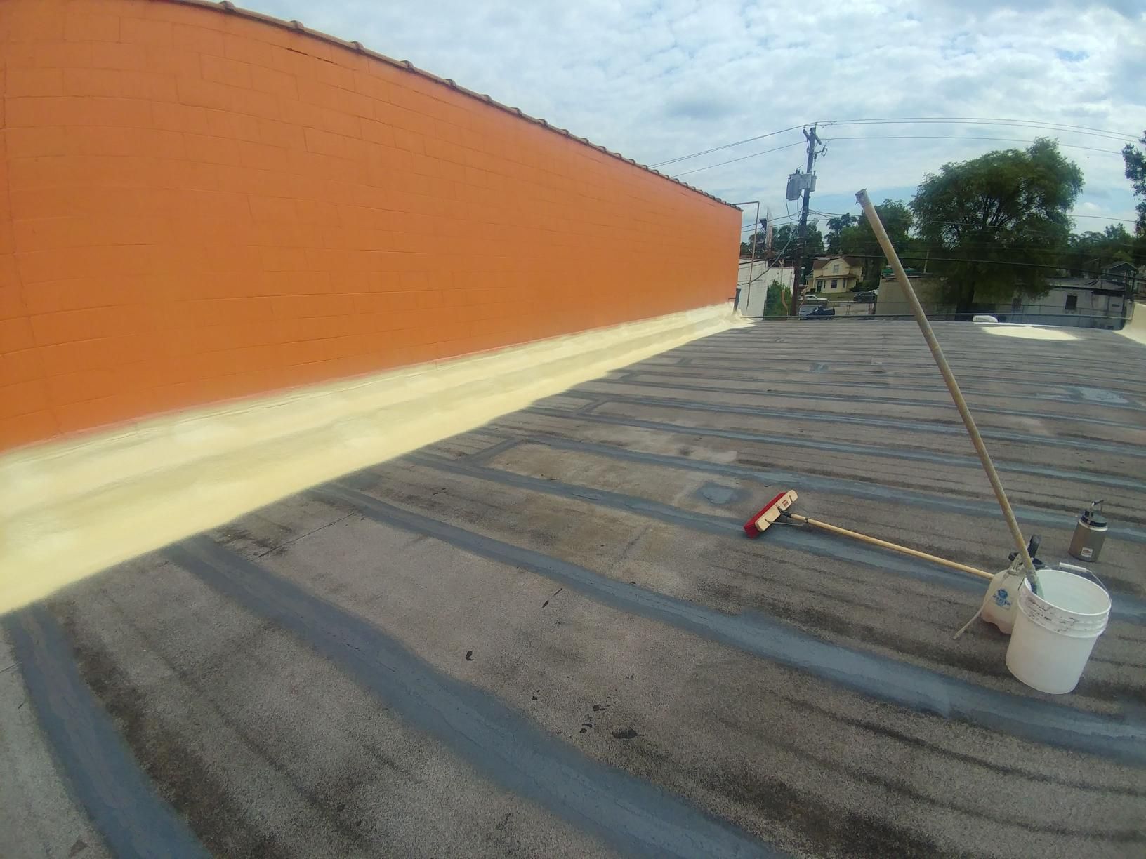 A roof with a broom and bucket on it.