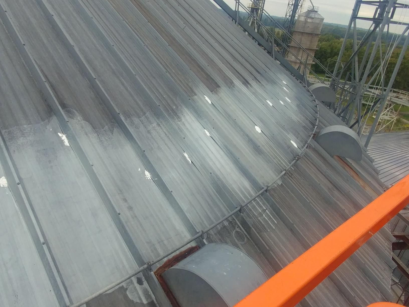 The roof of a building is being painted white