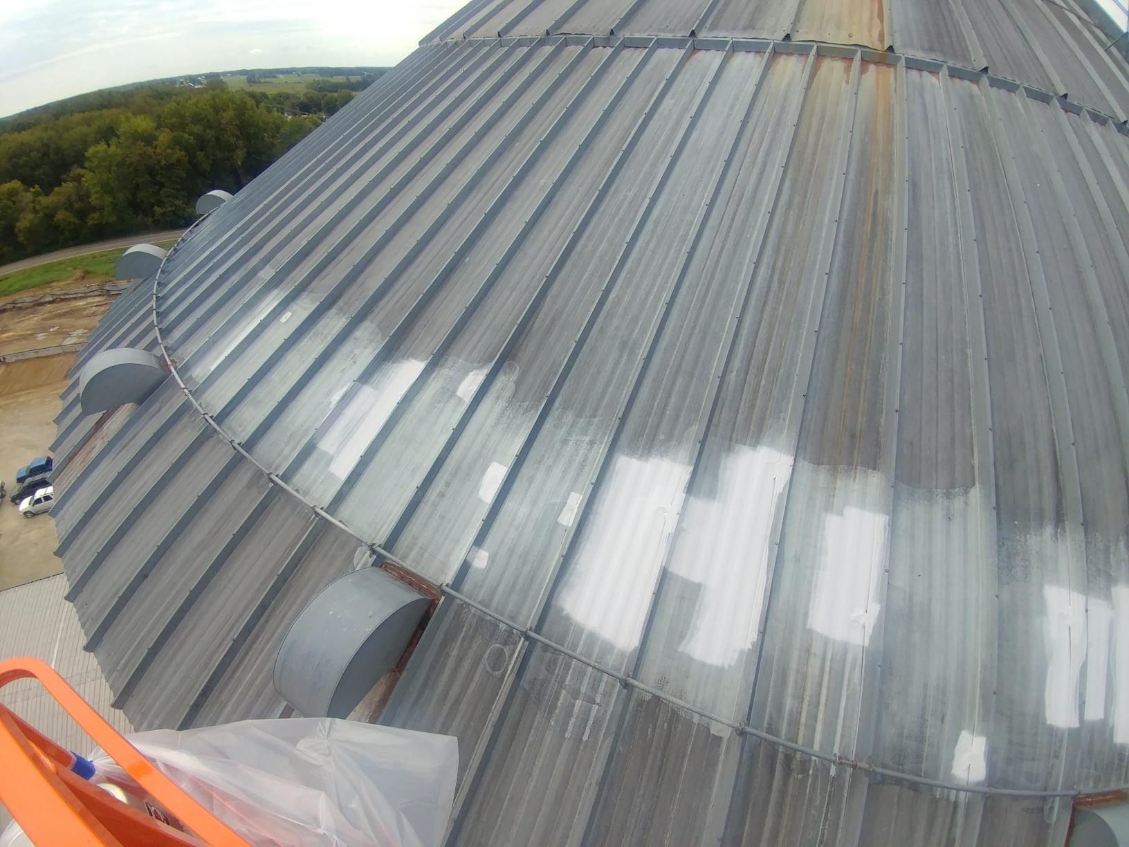 The roof of a building is being painted white