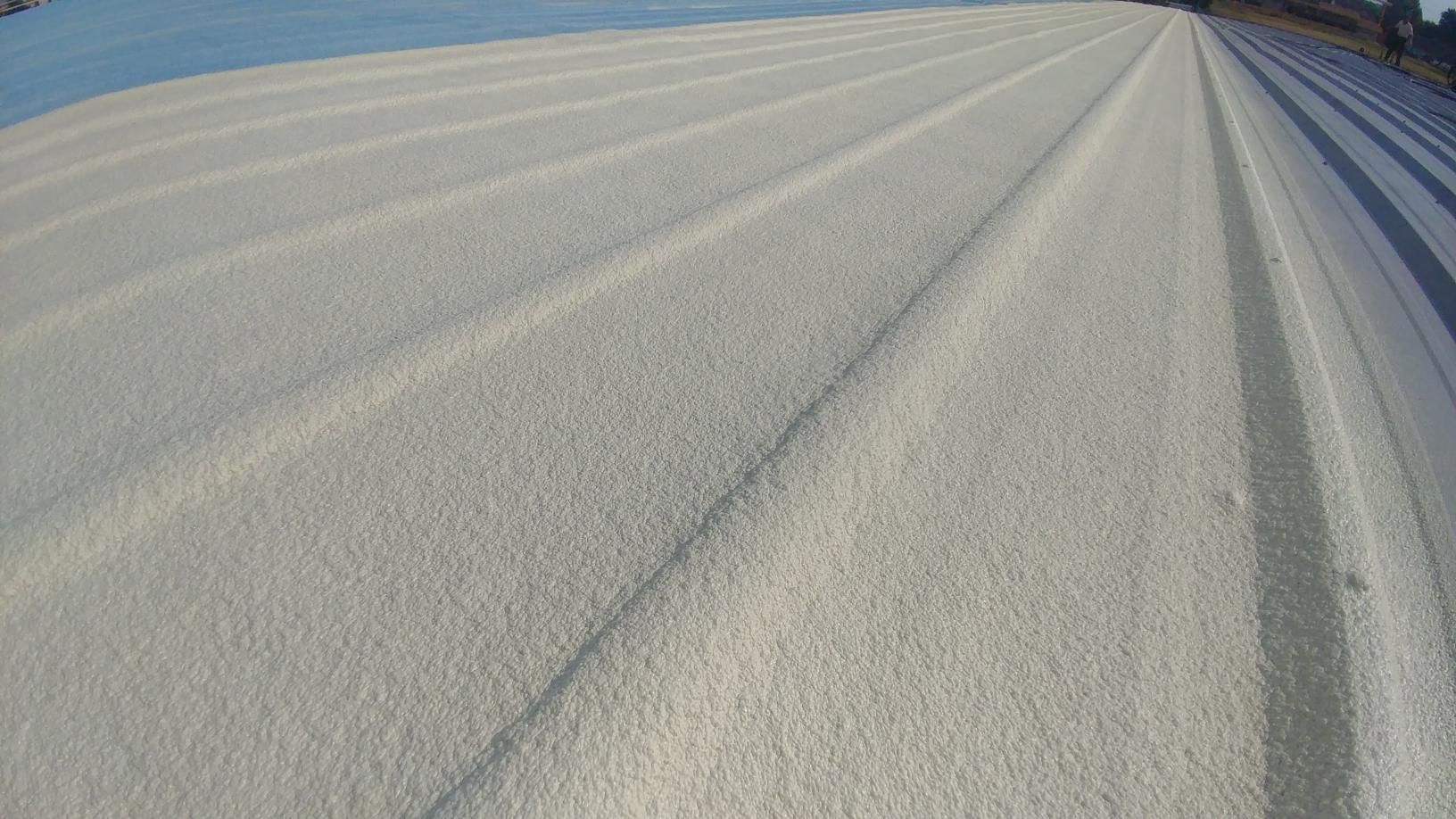 A close up of a white roof with a lot of snow on it.