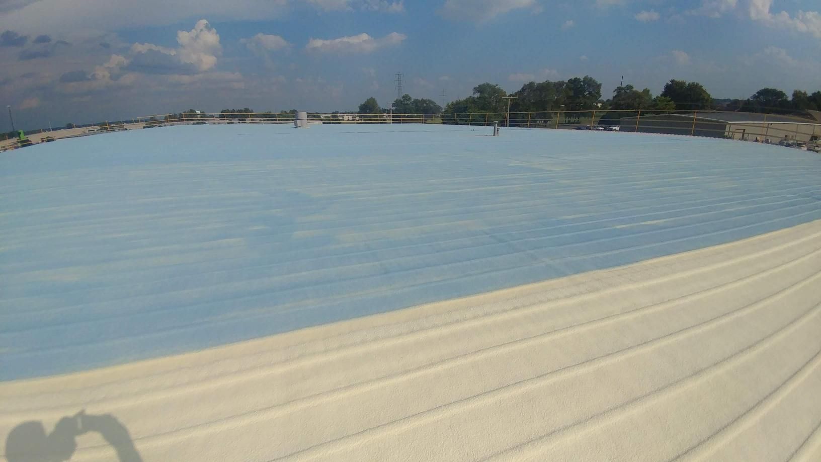 A large white roof with a blue sky in the background.