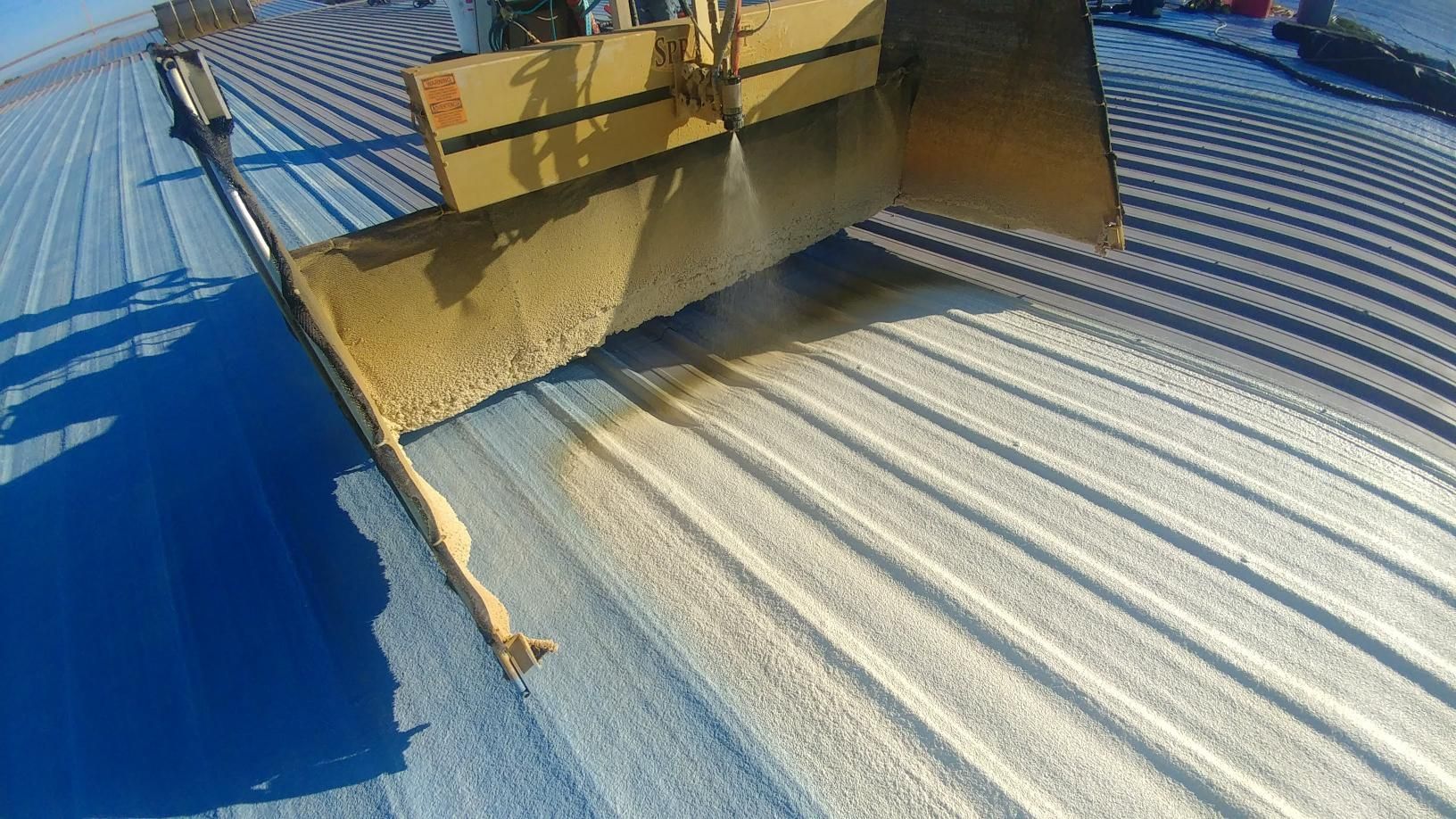 A bulldozer is cleaning the roof of a building.
