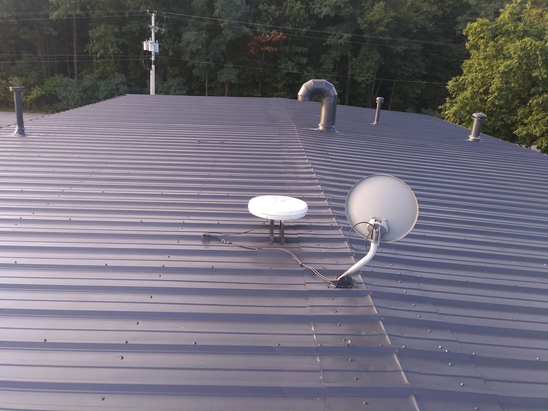 A satellite dish is sitting on the roof of a building.