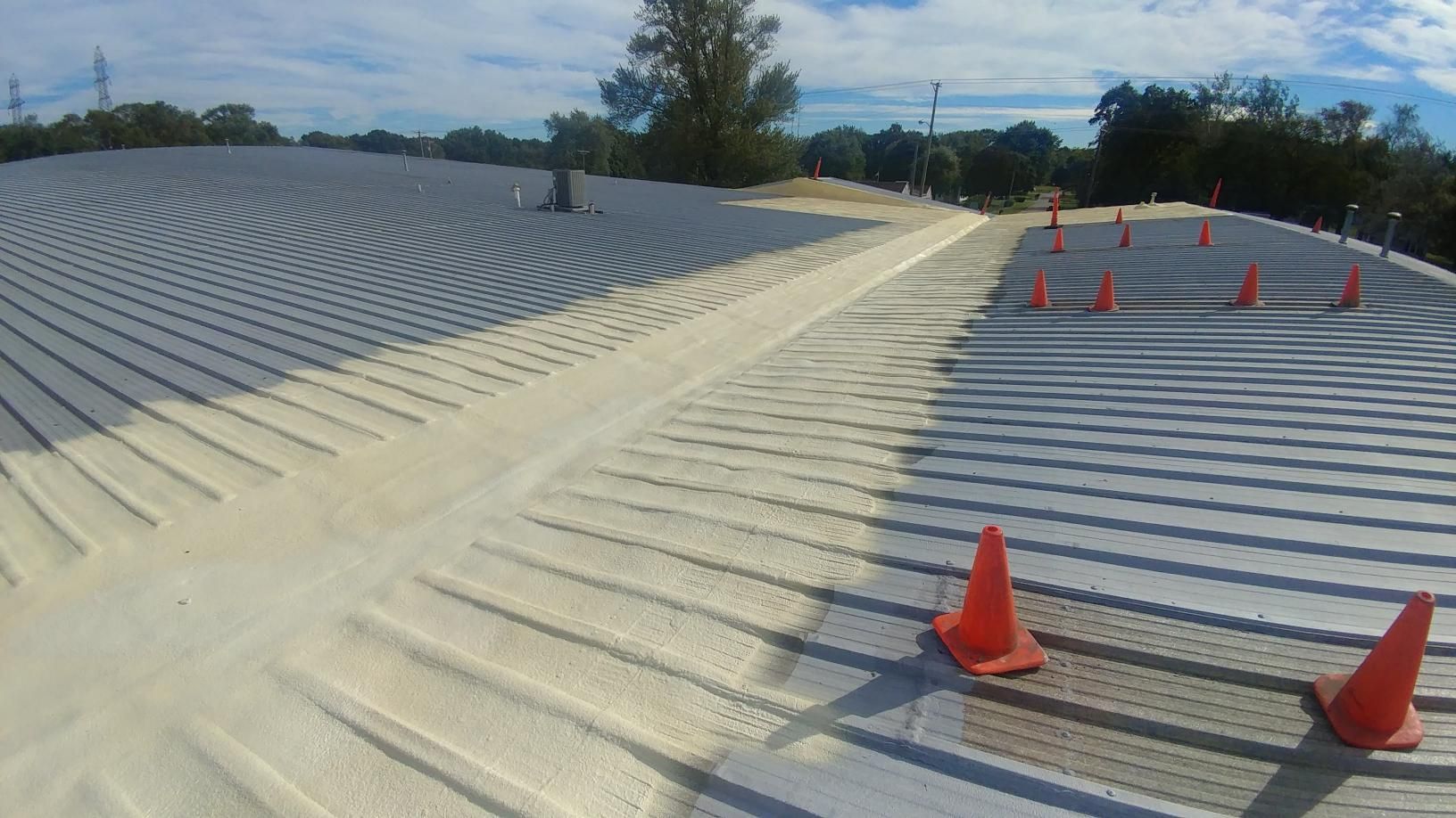 A roof with a lot of foam on it and orange cones on it.
