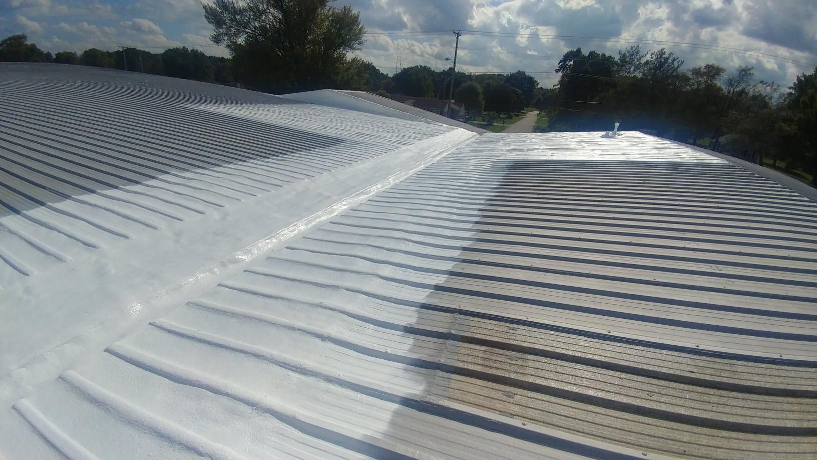 The roof of a building is being painted white.