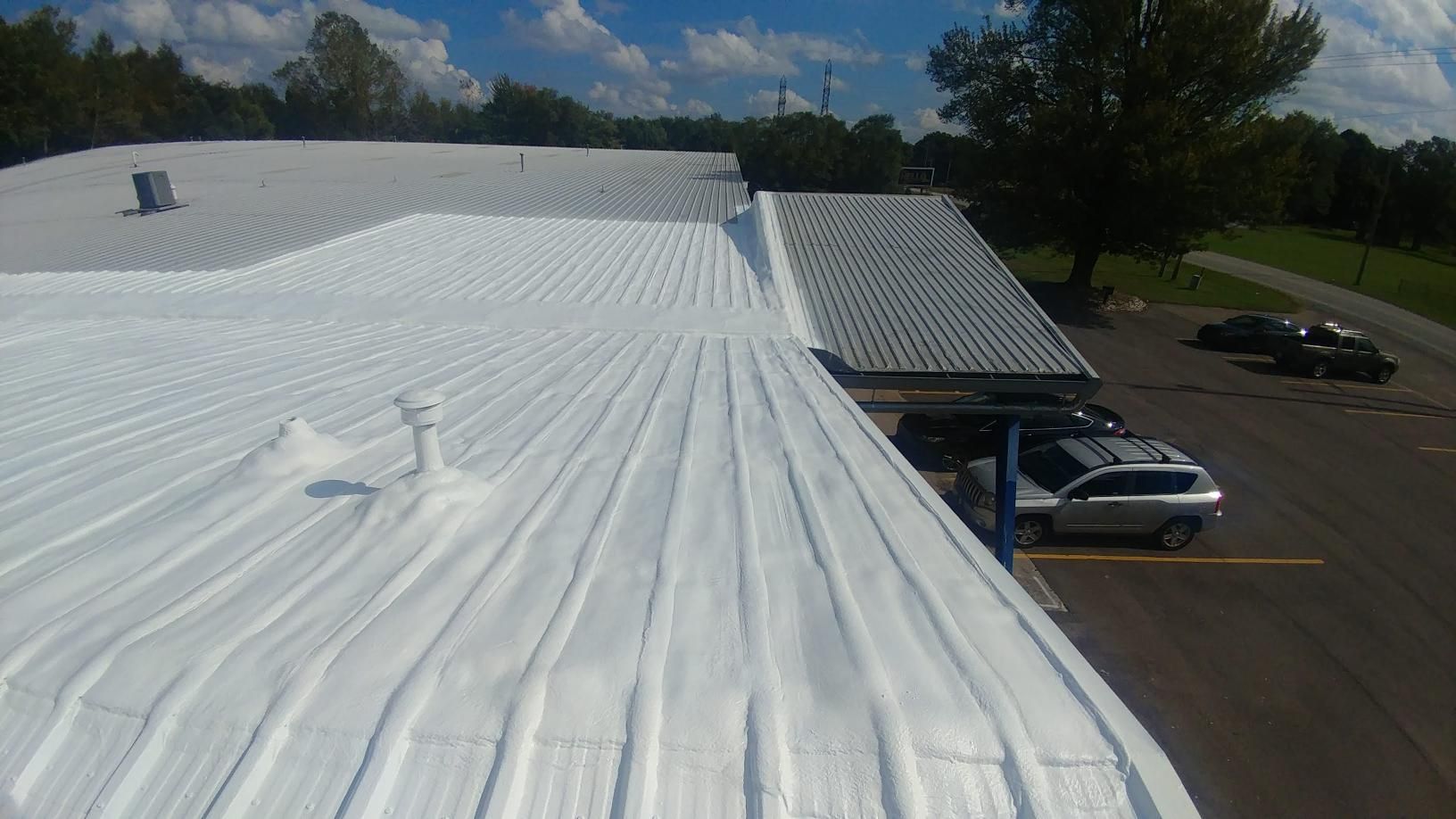 A white roof with a lot of cars parked on it.