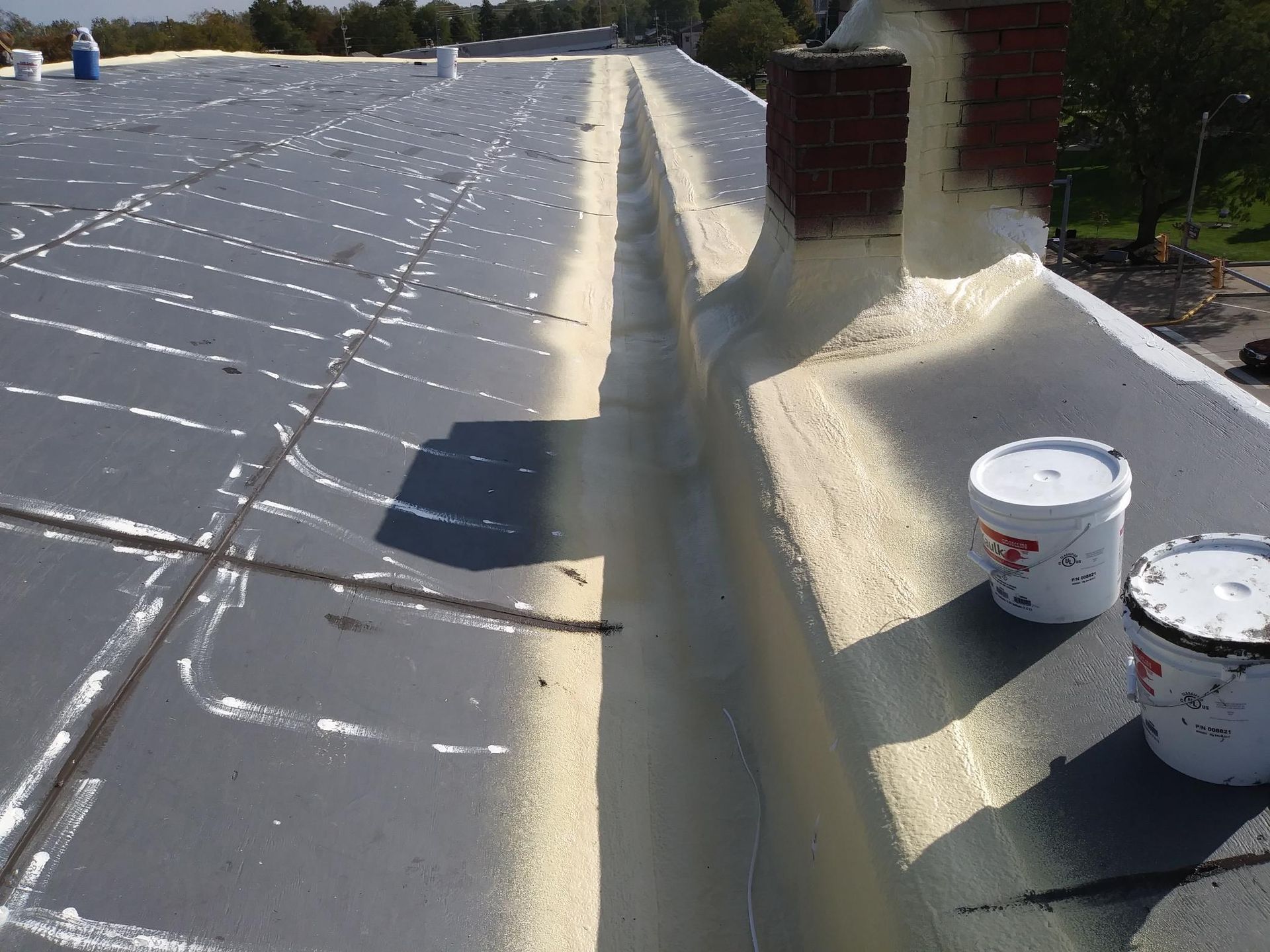 Two buckets of paint are sitting on top of a roof
