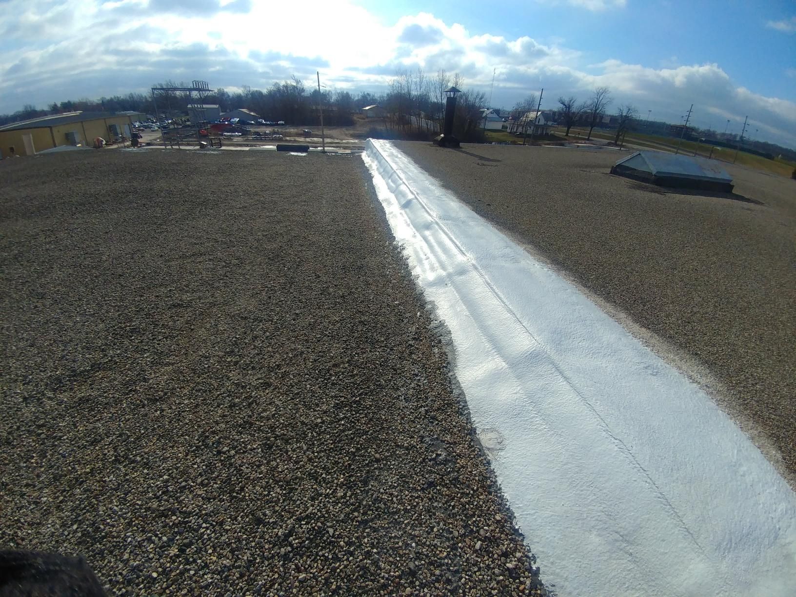 A roof with gravel and a white line on it