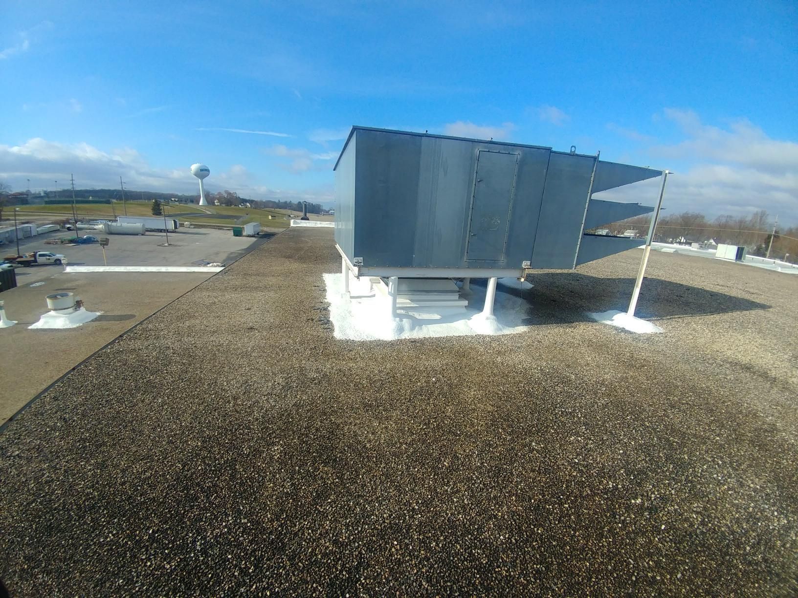 The roof of a building with a water tower in the background.