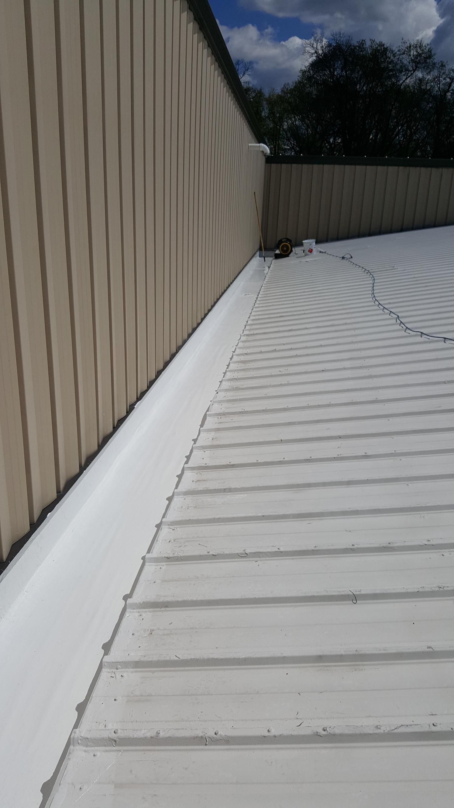 A white roof with a white gutter on the side of a building.