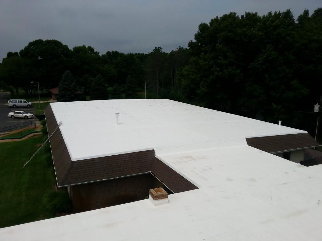 A white roof of a building with trees in the background