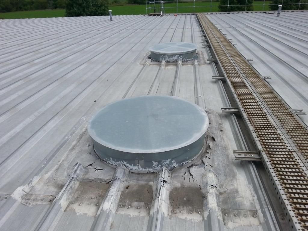 A metal roof with two round skylights on it