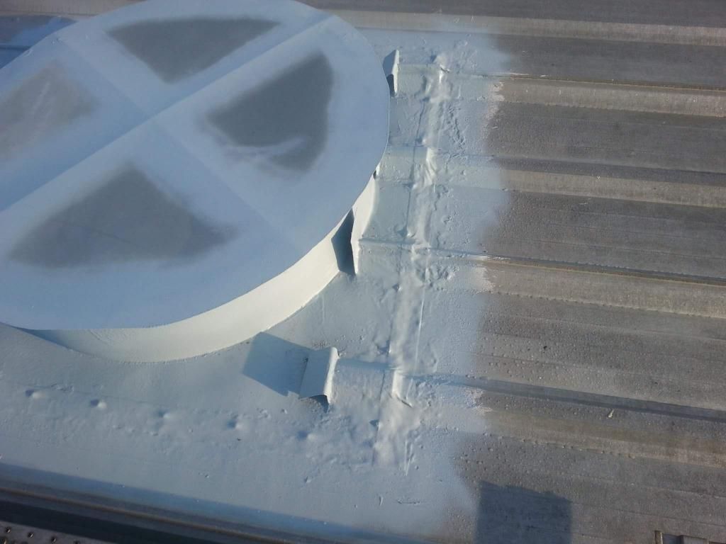 The roof of a building is being painted white