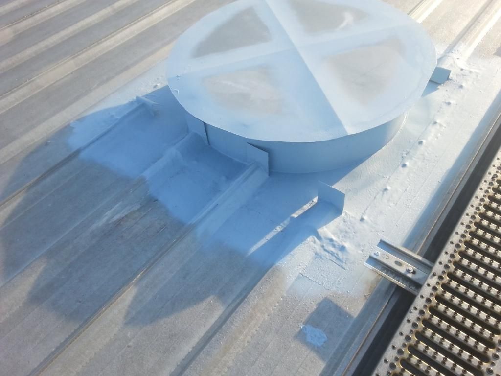 A white circular object is sitting on top of a metal roof.